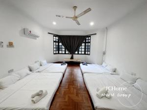 a room with three beds in it with a window at Kempas Bungalow with KTV SwimmingPool in Johor Bahru