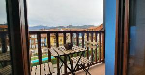a balcony with a wooden bench and a view of a building at Precioso Ático con Vistas en El Capricho de Colombres, Asturias in Colombres