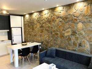 cocina con mesa y pared de piedra en Marilia & Myronas Lemnos Apartments, en Mirina