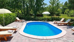 una piscina con sillas y sombrillas en un patio en Apartment Sonja 1, en Šilo