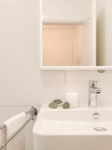 ein Badezimmer mit einem weißen Waschbecken und einem Spiegel in der Unterkunft Ferienwohnung Sonnenglück mit großzügigem Südbalkon in Lenzkirch