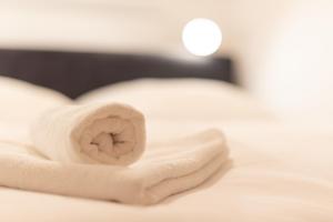 eine Rolle weiße Handtücher auf einem Bett in der Unterkunft Ferienwohnung Sonnenglück mit großzügigem Südbalkon in Lenzkirch