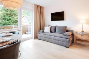 ein Wohnzimmer mit Sofa und Tisch in der Unterkunft Ferienwohnung Sonnenglück mit großzügigem Südbalkon in Lenzkirch