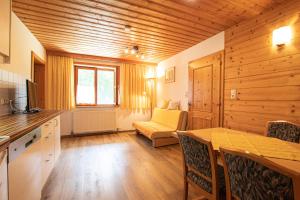 Una cocina con una mesa y un sofá en una habitación. en Ferienwohnung Wilder Kaiser Nähe Bergdoktor Drehorte IDT098 by FeWo-Plan, en Itter