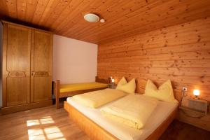 Un dormitorio con una cama en una pared de madera. en Ferienwohnung Wilder Kaiser Nähe Bergdoktor Drehorte IDT098 by FeWo-Plan, en Itter