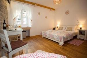 a bedroom with two beds and a desk and a window at Luxury Room Kokola in Split