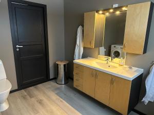 ein Badezimmer mit Waschbecken, Toilette und Spiegel in der Unterkunft Large apartment with great views in Senja + 47 Fotos