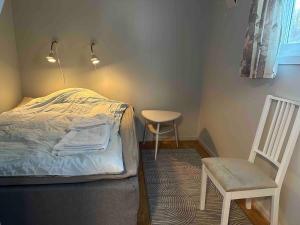ein Schlafzimmer mit einem Bett, einem Stuhl und einem Tisch in der Unterkunft Large apartment with great views in Senja