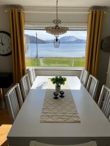 einen Esstisch mit Blick auf das Wasser in der Unterkunft Large apartment with great views in Senja