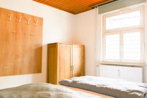 a bedroom with a bed and a wooden cabinet at Ferienwohnung Neu "Zum Westerwald" LAHN02 in Löhnberg +7 photos