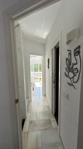 ein Flur mit einer weißen Wand mit einem Gemälde darauf in der Unterkunft Casa Costa del Sol Beach&Golf,Marbella in Sitio de Calahonda