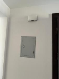 a white wall with a clock on it at كومبوند سراي in Cairo