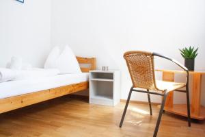 a bedroom with a chair and a bed with white sheets at Royal 4 Trend by Alpenidyll Apartments in Liezen