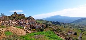 a village on a hill with a mountain in the background at Benvenuti alla Red House dei Nebrodi in Cesarò