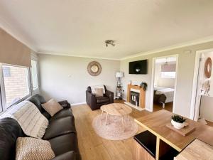 a living room with a couch and a table at 55 Florida Park Hemsby in Great Yarmouth