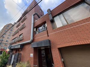 a red brick building with a pipe on the side of it at LUANAHOTEL IN SINNAKANO in Tokyo