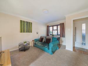 a living room with a blue couch and a table at Hersham Apartment Ideal for Work & Relaxation - Pass the Keys in Hersham +10 photos