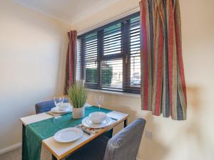 a dining room table with chairs and a window at Hersham Apartment Ideal for Work & Relaxation - Pass the Keys in Hersham