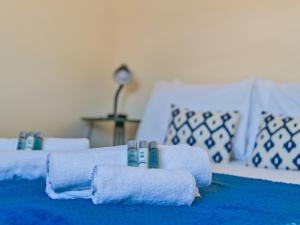 two beds with blue and white towels on them at Hersham Apartment Ideal for Work & Relaxation - Pass the Keys in Hersham