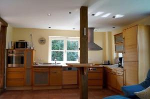 a large kitchen with wooden cabinets and a window at Reethaus Mertinat For Six in Brandenhusen