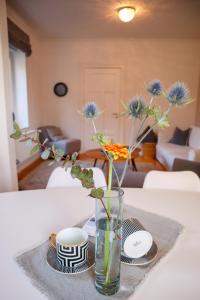 a vase with flowers in it sitting on a table at FeWo Dünenrose in Dahme +12 photos