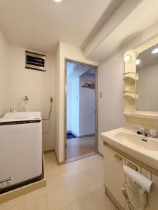 a bathroom with a sink and a mirror at Residence Yu by b hotel - Quiet & Cozy Apartments Steps from City Center in Hiroshima