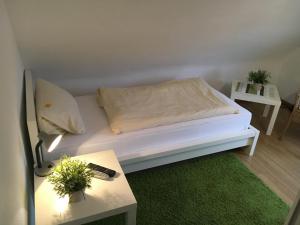 Cette chambre comprend un lit blanc avec une table et un canapé. dans l'établissement Landgasthof Drei Eichen, à Wilnsdorf