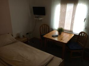 Un dormitorio con una cama y una mesa con una planta. en Landgasthof Drei Eichen, en Wilnsdorf