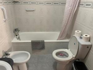 a bathroom with a toilet and a tub and a sink at Plaza Mare Nostrum 5 min playa in Puerto de Sagunto +6 photos