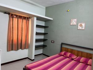 a bedroom with a bed and a book shelf at SHI's 2BHK home in Coimbatore near Sai Baba Colony, Ganga C Hospital, Women's care in Coimbatore