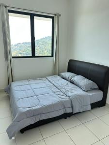 una cama en una habitación con una ventana grande en HappySty, en Bayan Lepas