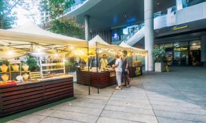 a couple of people standing in front of a market at The Vibrant Condo Cool Stays 4254 Memorable Swim Gym Park Laugh in Manila