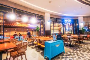 a restaurant with tables and chairs and people sitting at tables at The Vibrant Condo Cool Stays 4254 Memorable Swim Gym Park Laugh in Manila