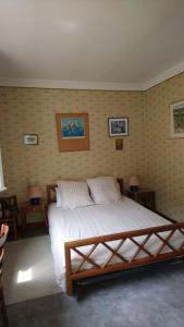 - une chambre avec un lit et 2 tables avec des lampes dans l'établissement Le pré de Bonhomme, à Le Mazeau