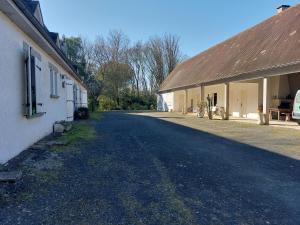 une route vide à côté d'un bâtiment avec toit dans l'établissement Le pré de Bonhomme, à Le Mazeau