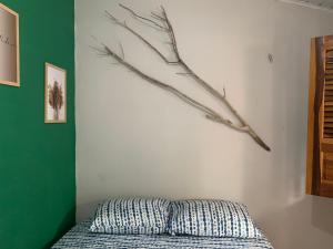 una camera da letto con un letto con un ramo sul muro di III Chalés O Sertanejo BG a Barra Grande Altre 7 foto