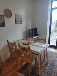 a dining room table with chairs and a clock on the wall at Boho House Terrace in Porto