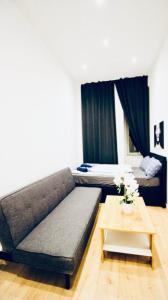una sala de estar con un sofá y una mesa en Super Central Cozy 5 BR Shared Apt 10Min Walk to Augarten, en Viena