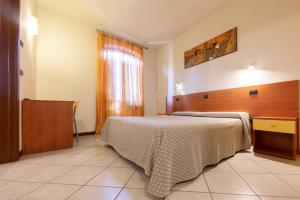 a hotel room with a bed and a window at La Vecchia Tramvia in Castiglione delle Stiviere +2 photos