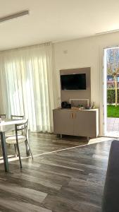a living room with a flat screen tv and a table at Mazzini Green Suites Jesolo in Lido di Jesolo
