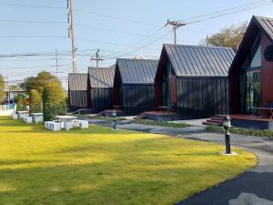 a row of buildings with grass and benches in front at Nordic SkyBird Hill Chill in Pak Chong