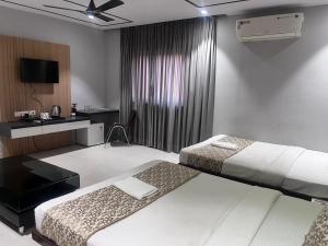 een hotelkamer met twee bedden en een bureau bij HOTEL SHIVGANGA COMFORT ZONE, Raipur in Raipur +48 foto's