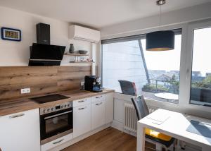 梅尔斯堡Ferienapartment Seeblick的厨房配有白色橱柜、桌子和窗户