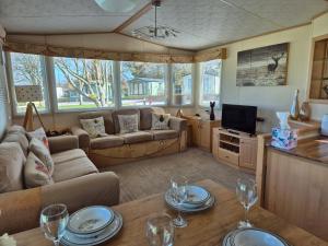 a living room with a couch and a tv at 24 The Beeches Caravan Park in Gilcrux