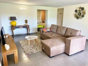 a living room with a couch and a table at Villa le Cotonnier Lodge in Saint-François