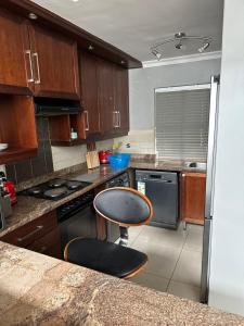 a kitchen with a counter and a chair in it at YA Eagle Wings Self Catering Shared Single room Apt B in Cape Town +7 photos