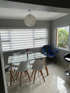 a dining room with a glass table and chairs at YA Eagle Wings Self Catering Shared Single room Apt B in Cape Town