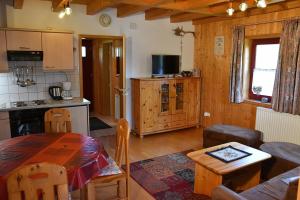 a kitchen and living room with a table in a room at Ferienhaus Nr 10B2, Feriendorf Hagbügerl, Bayr Wald in Waldmünchen