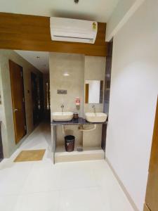 a bathroom with two sinks and a air conditioner at Hotel Status Residency in Navi Mumbai