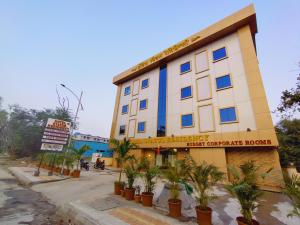 a hotel building with plants in front of it at Hotel Status Residency in Navi Mumbai